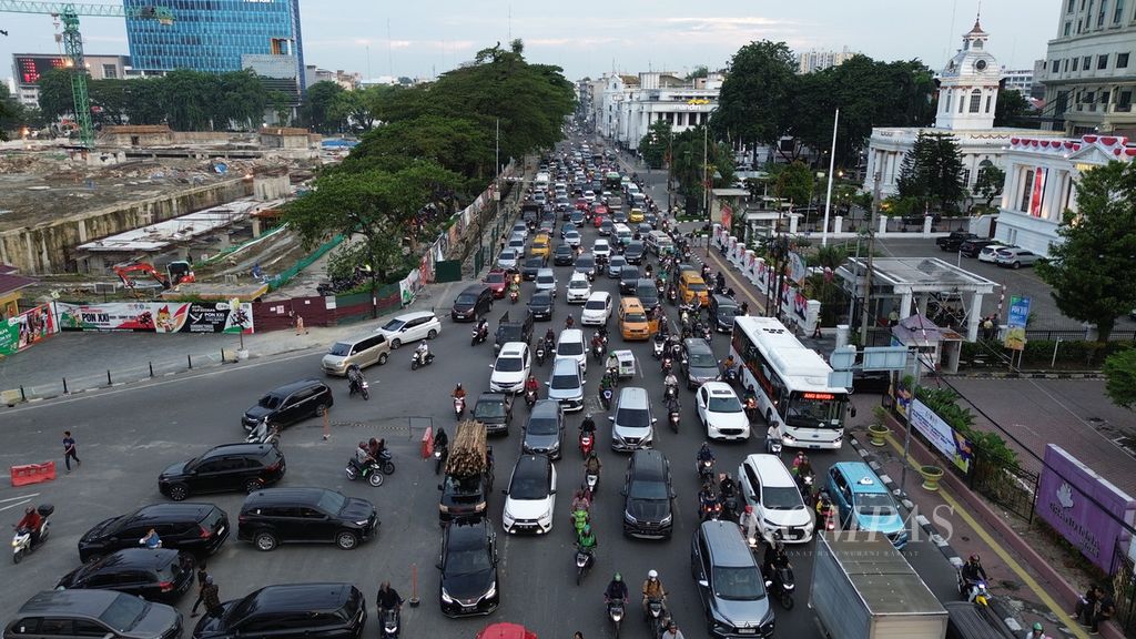 Bus listrik (kanan) menembus kemacetan lalu lintas di Jalan Balai Kota sebelum tiba di halte sementara <i>bus rapid transit</i> (BRT) Lapangan Merdeka, Medan, Sumatera Utara, Selasa (10/9/2024). 