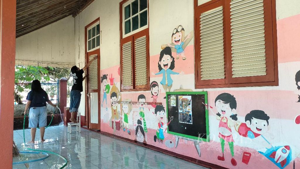 Sejumlah guru membersihkan sisa abu vulkanik di jendela, lorong dan sekitar ruang kelas di TK Kanisius Pendowo, Kota Magelang, Senin (13/3/2023). Karena lingkungan sekolah yang berdebu terpapar abu, murid TK diminta untuk belajar di rumah hingga Rabu (15/3/2023).