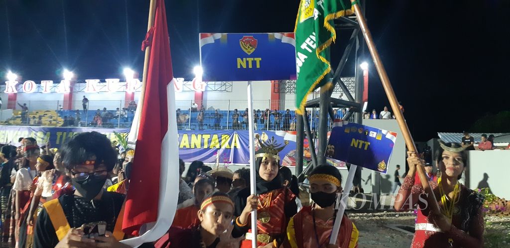 Seorang gadis Muslim membawa papan nama provinsi saat pawai kontingen dalam acara pembukaan Pesparani Nasional II di Kota Kupang, Nusa Tenggara Timur, Jumat (28/10/2022). Keterlibatan umat lintas agama menunjukkan bukti persaudaraan masyarakat NTT.