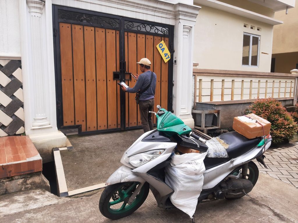 Damiri (42), kurir ekspedisi, menyerahkan barang kepada pelanggan di kawasan Kelurahan Gaga, Tangerang, Banten, Kamis (9/3/2023). Kisah kehidupan kurir menjadi salah satu sisi liputan Suara Tak Terdengar bertema Kesejahteraan Kuli Angkut". 