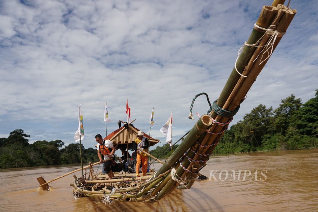 Tim Milir Berakit Sungai Batanghari mengayuhkan batang bambu agar rakit dapat melaju lebih cepat menuju hilir, Kamis (17/11/2022). Tanpa menggunakan bantuan mesin, rakit melaju pelan-pelan. Tim diperkirakan mencapai hilir dalam lima hari perjalanan.