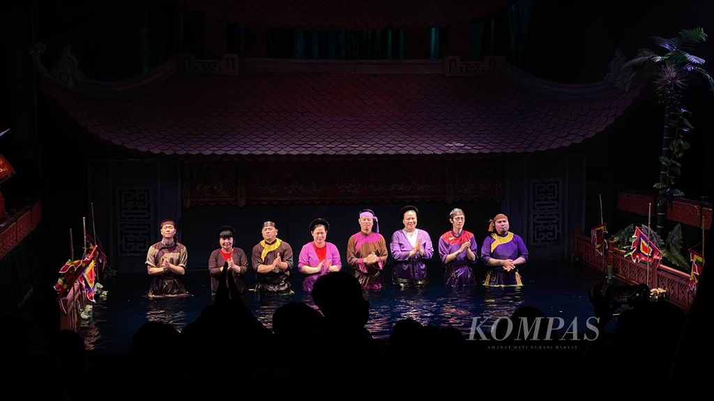 Sejumlah seniman yang menggerakkan boneka kayu tampil di akhir pertunjukan di Thang Long Water Puppet Theater, Hanoi, Vietnam, Jumat (20/5/2022). Pertunjukan <i>water puppet </i>yang menyerupai pertunjukan wayang golek di Indonesia ini menceritakan tentang Raja Le Loi yang mengembalikan pedang sakti kepada Raja Naga melalui bantuan kura-kura di Danau Hoan Kiem.