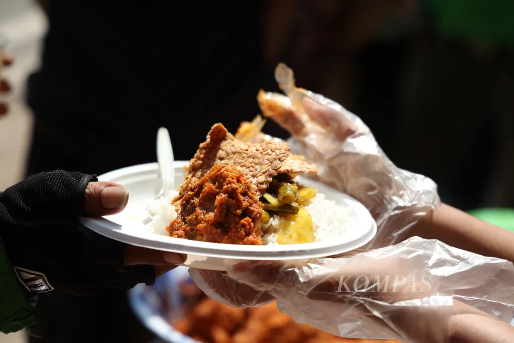Menu makan siang gratis yang dibagikan oleh Yayasan Damaris Pancasila Indonesia di Jalan Raya Lenteng Agung, Jakarta, Kamis (27/6/2024}. Makan siang gratis ini dilaksanakan dua minggu sekali di tempat yang sama. Relawan yang tergabung berasal dari beragam latar belakang agama, suku, dan ras. Pembagian makan siang gratis ini telah berlangsung selama empat tahun terakhir. Kompas/Hendra A Setyawan