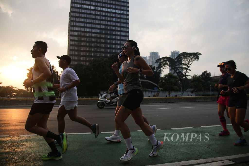 Warga berlari di Jalan Jenderal Sudirman, Jakarta, Rabu (22/3/2023). Libur hari raya Nyepi yang bertepatan dengan sehari menjelang puasa Ramadhan dimanfaatkan masyarakat untuk olahraga. 