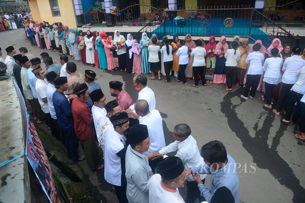  Hundreds of residents shake hands with each other along a rural road during the Idul Fitri  celebration in Tekelan Hamlet, Batur Village, Getasan District, Semarang Regency, Central Java, Monday (2/5/2022). The hamlet, which is inhabited by around 700 residents, embraces various religions, including Islam, Christianity and Buddhism.