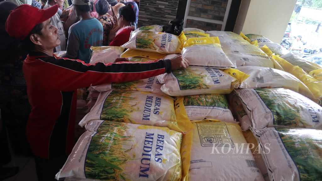 Warga melihat tumpukan beras saat operasi pasar murah di Desa Galagamba, Kecamatan Ciwaringin, Kabupaten Cirebon, Jawa Barat, Senin (27/2/2023).