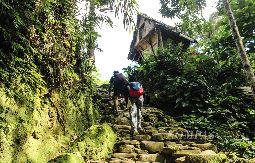 Pengunjung melewati tanjakan di Baduy Luar, Desa Kanekes, Kecamatan Leuwidamar, Kabupaten Lebak, Banten, Sabtu (15/6/2024).