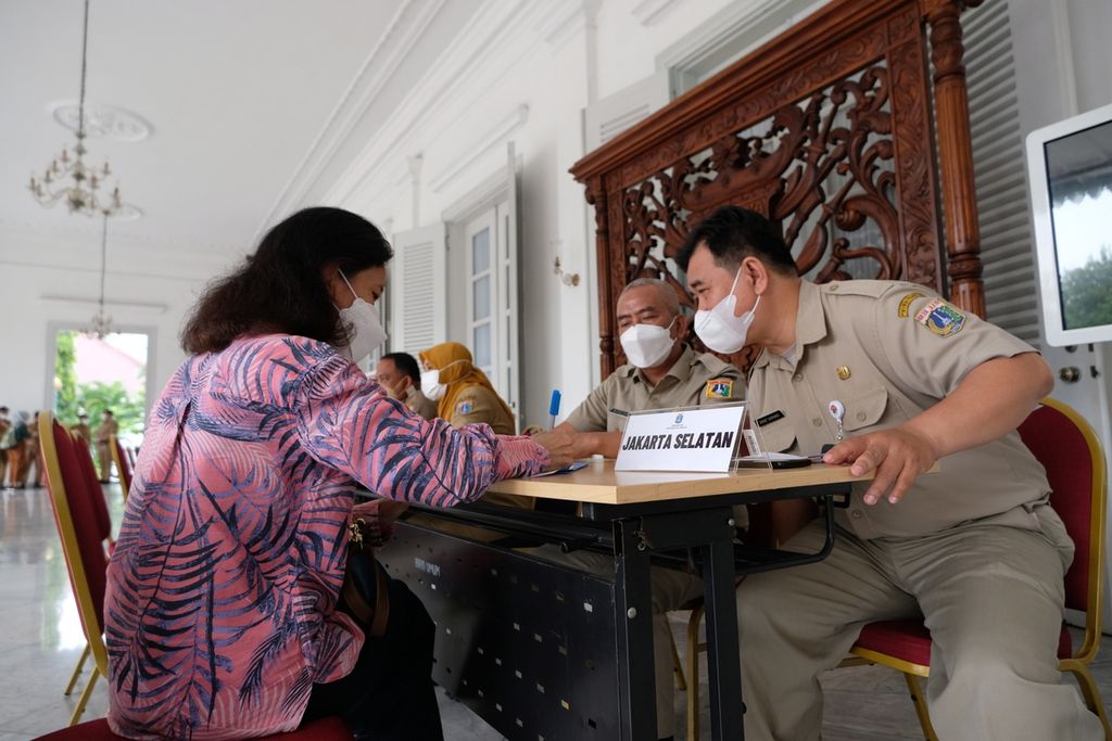 Petugas pelayanan membantu warga untuk mengisi formulir di pendopo Balai Kota DKI Jakarta, Selasa (18/10/2022). Pelayanan pengaduan masyarakat di pendopo Balai Kota DKI Jakarta kembali dibuka setelah berpindah menuju ke kecamatan dan kelurahan pada kepemimpinan Anies Baswedan. Pelayanan pengaduan masyarakat ini dibuka pada hari Senin sampai Jumat dari pukul 07.30 sampai pukul 09.30.