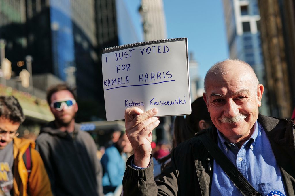 Seorang pendukung kandidat presiden Partai Demokrat Kamala Harris memperlihatkan tulisan tangannya saat berkumpul di depan Madison Square Garden, New York, Minggu (27/10/2024), yang menjadi lokasi kampanye Donald Trump, capres Partai Republik.