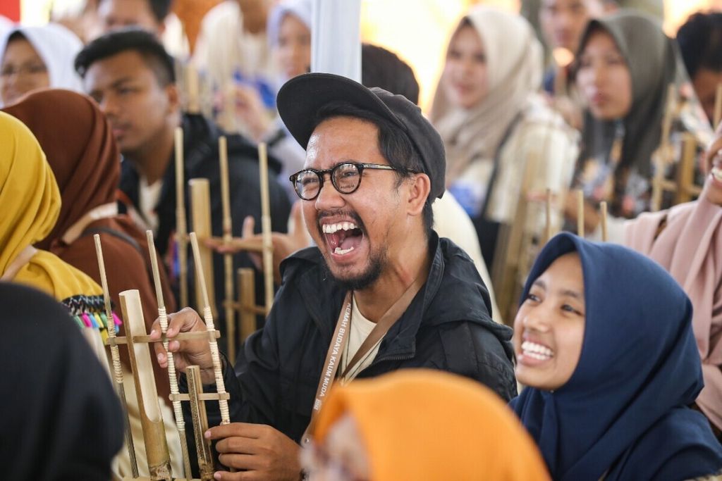 Anak-anak muda peserta Kemah Budaya Kaum Muda 2019 mencoba bermain angklung di Bumi Perkemahan Prambanan, Sleman, DIY 