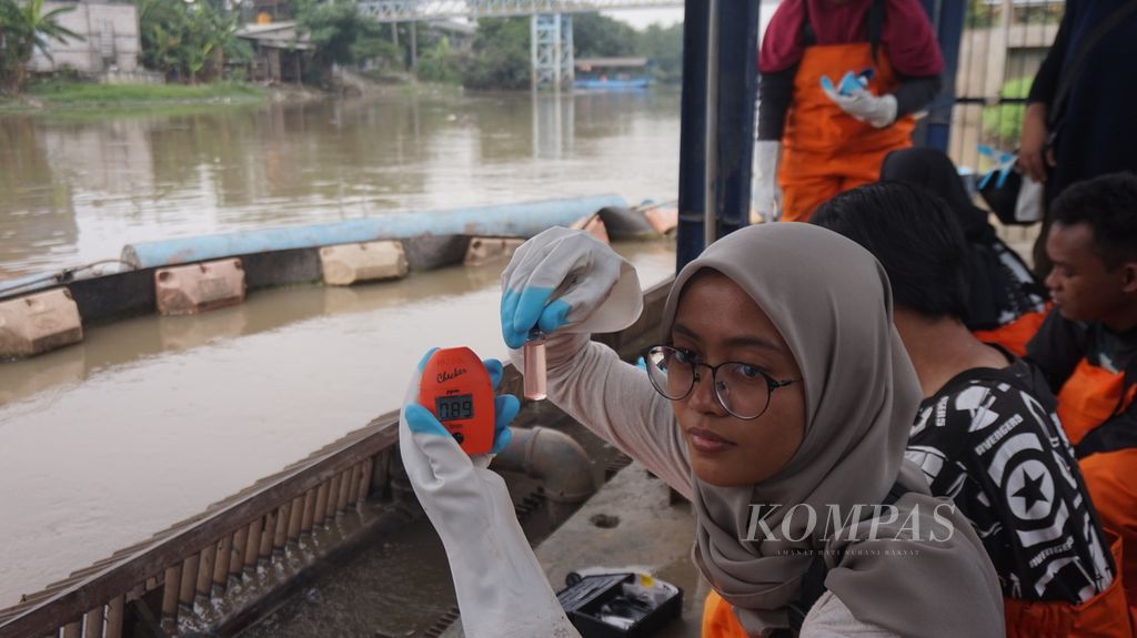Mahasiswi magang pada Lembaga Kajian Ekologi dan Konservasi Lahan Basah (Ecoton) memperlihatkan hasil pengecekan kandungan besi atau air baku Kali Surabaya di pipa masuk (<i>inlet</i>) Instalasi Penjernihan Air Minum (IPAM) Karangpilang, Surabaya, Jawa Timur, Selasa (21/3/2023). Kandungan oksigen terlarut, amonia, besi, dan fosfor kurang bagus sehingga dalam pengolahan memerlukan upaya ekstra dengan pencampuran tawas dan obat kimia.