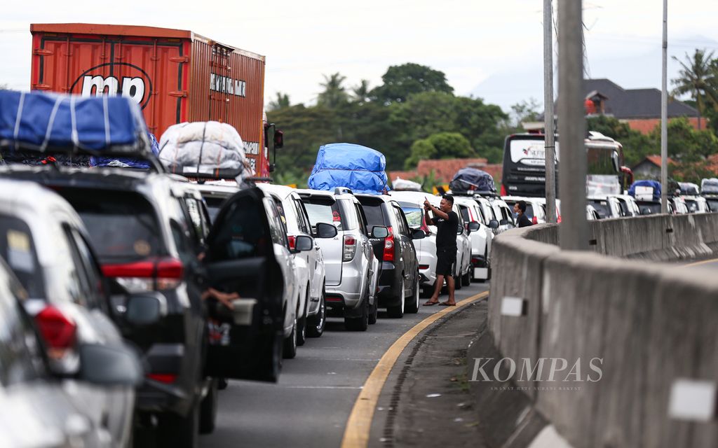 Pemudik keluar dari kendaraannya saat terjebak macet di Kilometer 96 jelang pintu keluar gerbang tol Merak di Cilegon, Banten, Kamis (28/4/2022). 