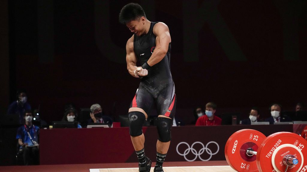 Lifter Indonesia, Rahmat Erwin Abdullah, menunjukkan otot tubuhnya seusai mengangkat beban dalam lomba angkat besi kelas 73kg putra Olimpiade Tokyo 2020 di Tokyo International Forum, Tokyo, Jepang, Rabu (28/7/2021). Rahmat meraih emas kelas 73 kilogram dan memecahkan rekor dunia angkatan <i>clean & jerk</i> dengan 200 kg dalam Kejuaraan Dunia Angkat Besi 2022 di Gran Carpa Americas Corferias, Bogota, Kolombia, Sabtu (10/12/2022) waktu Indonesia.  