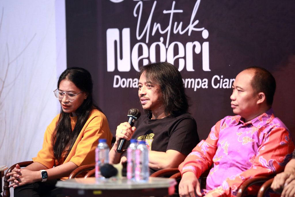 Gitaris Dewa Budjana (tengah) berbicara dalam konferensi pers pra-acara Konser Amal Gitaris untuk Negeri: Donasi Gempa Cianjur di Bentara Budaya Jakarta, Jakarta, Senin (5/12/2022). Pada 7 Desember 2022 akan diadakan konser amal bertajuk “Gitaris untuk Negeri: Donasi Gempa Cianjur” di Bentara Budaya Jakarta. Konser ini akan menampilkan 48 musisi. Selain pertunjukan musik, acara ini juga akan menggelar lelang karya lukis dan gitar yang ditandatangani oleh para musisi. Semua hasil dari gelaran konser amal dan lelang akan diserahkan kepada korban gempa Cianjur melalui Yayasan Dana Kemanusiaan Kompas.