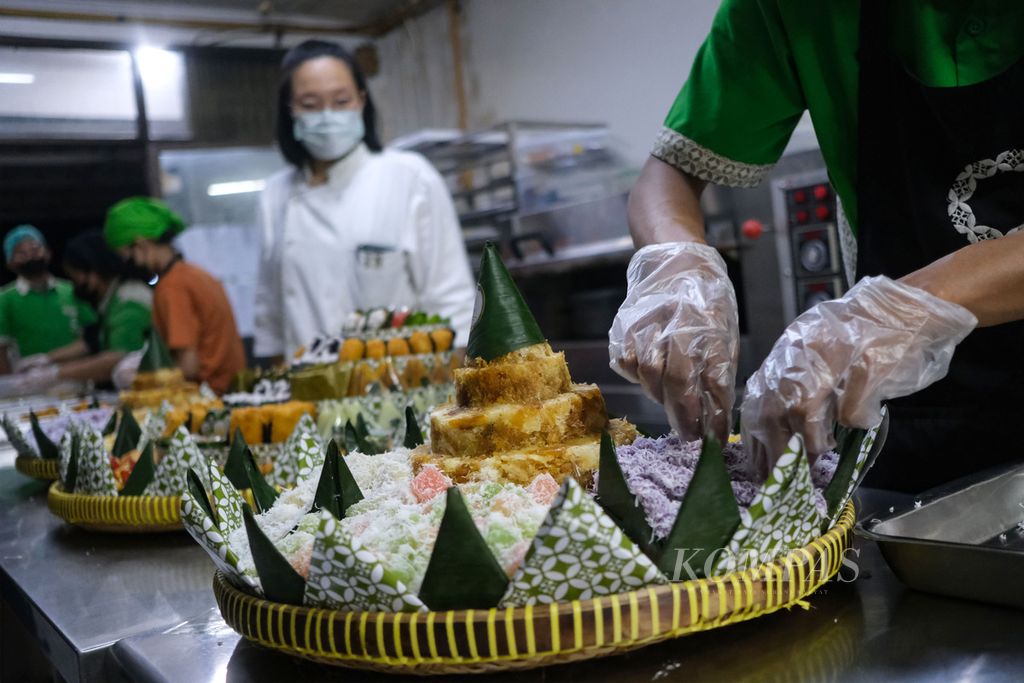 Pekerja menyiapkan tumpeng sawut, salah satu jajan pasar, sebelum dikirim ke pemesan di rumah produksi Iki Koue di Ruko Villa Melati Mas, Lengkong Karya, Serpong Utara, Kota Tangerang Selatan, Banten, Rabu (21/2/2024). Penganan tradisional yang dibuat Iki Koue tetap mempertahankan keaslian rasa, tapi bentuk dan penyajiannya dijadikan lebih praktis dan menarik. 