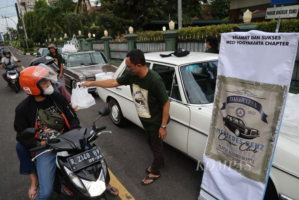 Anggota klub Mercedes-Benz Classic Club Indonesia (MCCI) Yogyakarta membagikan hidangan untuk berbuka puasa kepada pengguna jalan di kawasan Balai Kota Yogyakarta, Yogyakarta, DIY, Kamis (7/4/2022). Bulan Ramadhan menjadi momen bagi masyarakat untuk meningkatkan semangat berbagi dengan sesama dan berbuat kebaikan. Kegiatan tersebut dilakukan juga dalam rangka peringatan ulang tahun ke-10 klub tersebut.