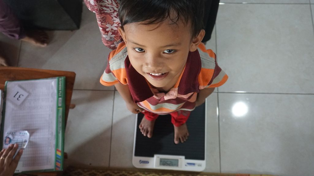 Seorang anak ditimbang berat badannya saat mendapatkan pelayanan di Posyandu Mawar Merah, Dusun Klangon, Sedayu, Bantul. Daerah Istimewa Yogyakarta, Jumat (10/2/2023).