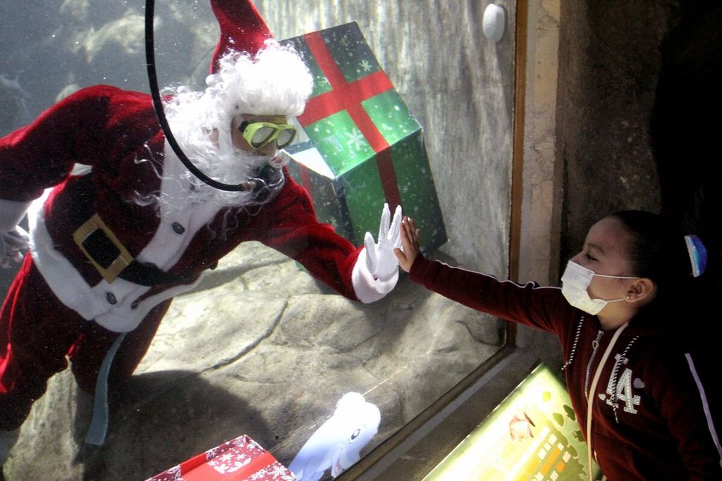 Penyelam yang berdandan sebagai Sinterklas menyapa pengunjung dari dalam akuarium Kebun Binatang Guadalajara menjelang libur Natal di Guadalajara, Meksiko, Sabtu (18/12/2021).