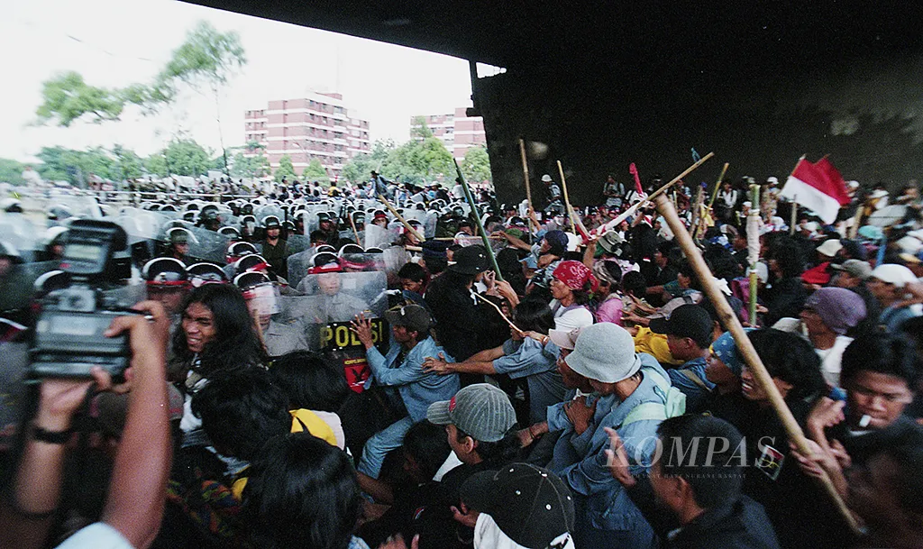 *** Local Caption *** Aksi-aksi mahasiswa, Jumat (8/5) merebak di berbagai kota dan umumnya berlangsung damai. Akant tetapi, demo di Solo, Yogyakarta, Samarinda dan Jakarta – khususnya di depan gedung MPR/DPR dan di sekitar kampus Univesitas Trisaksi Jalan Kyai Tapa-Jakarta, berlangsung rusuh. Secara khusus, demonstrasi di Jakarta, diwarnai dengan pelemparan batu terhadap aparat keamanan di Jl Kyai Tapa dan aparat bertindak tegas di Gedung MPR/DPR. Tampak bentrokan antara aparat keamanan dan pengunjuk rasa dekat Gedung DPR/MPR.   Terkait berita Kompas, 09-05-1998, 3. Judul Amplop : Demo Mahasiswa