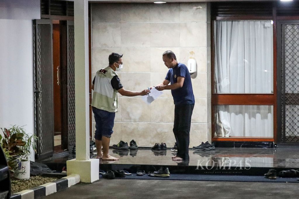 Investigators from the Corruption Eradication Commission (KPK) handed a piece of paper to the security guard at the official residence of Minister of Agriculture Syahrul Yasin Limpo on Widya Chandra V Street, Central Jakarta, on Thursday (28/9/2023). The KPK conducted a search of the house.