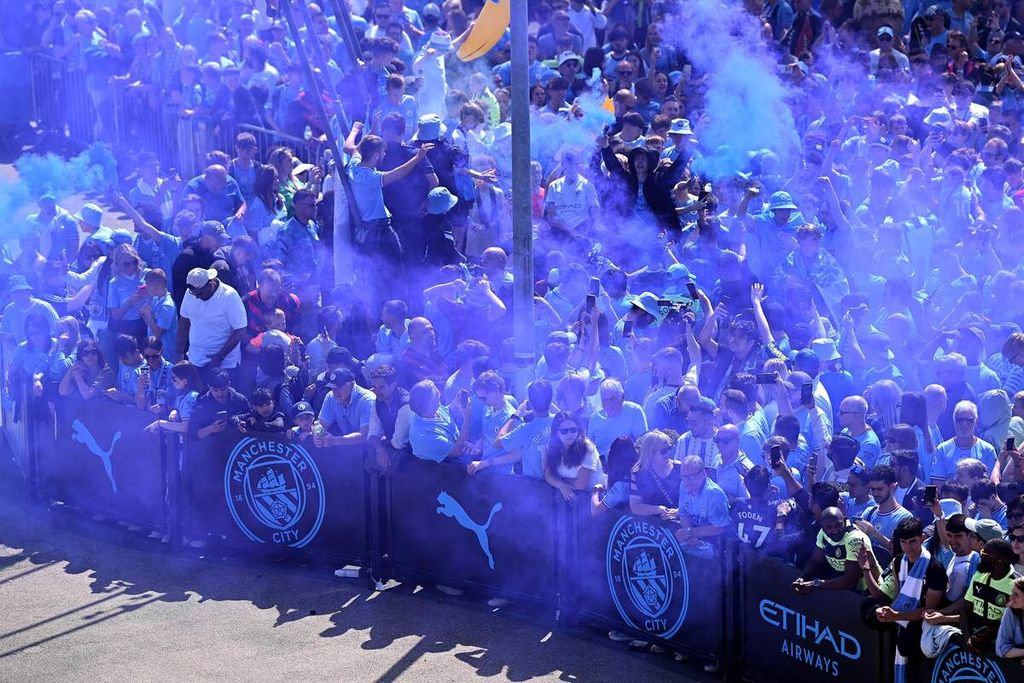 Penggemar Manchester City merayakan keberhasilan klub itu meraih gelar juara Liga Inggris musim 2022-2023, Minggu (21/5/2023), di Stadion Etihad, Manchester. City dipastikan menjadi juara setelah Arsenal dikalahkan Nottingham Forest, 0-1, sehari sebelumnya.