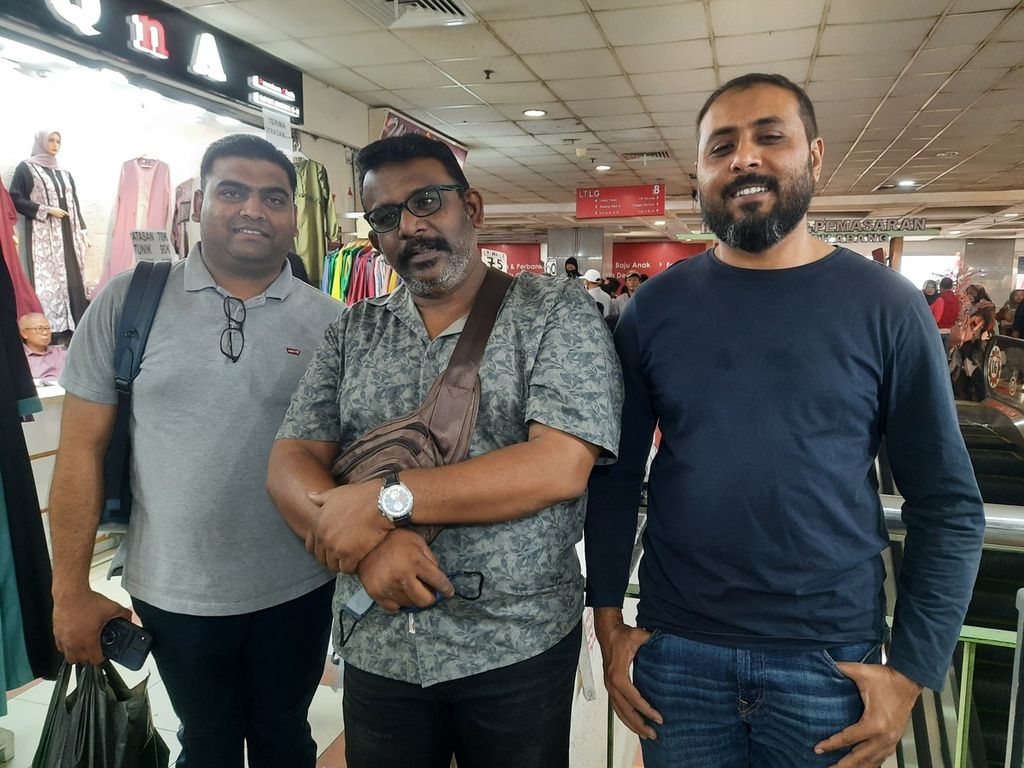Pengunjung dari mancanegara, Sashi (Malaysia), Rajin (Malaysia), dan Saif Mumtaz (Oman), mengunjungi kios peralatan shalat di Pasar Tanah Abang, Jakarta, Minggu (19/3/2023). Saif membatalkan niatnya membeli lantaran pakaian yang dijual tak dapat dicoba, sedangkan standar ukuran di Indonesia dan Oman berbeda.