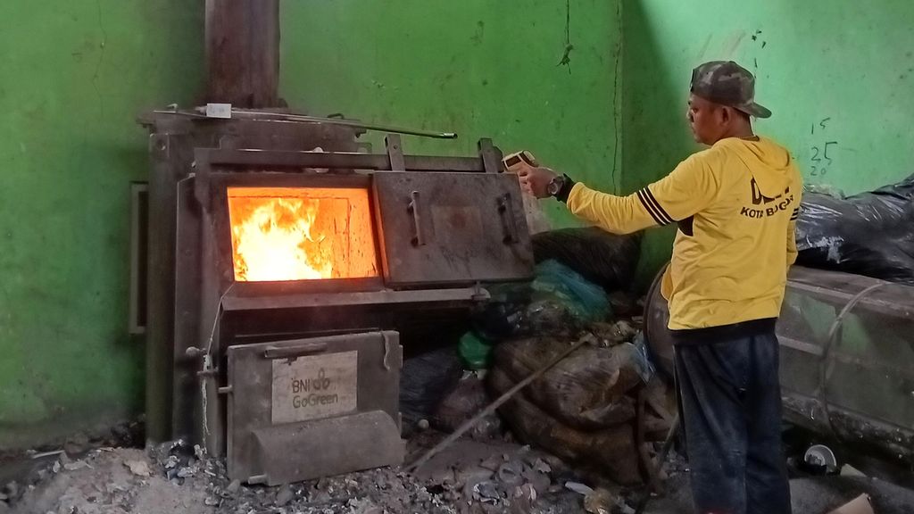 Petugas TPS3R Rangga Mekar, Bogor Selatan, Kota Bogor, Jawa Barat, saat memasukkan sampah anorganik ke dalam tungku pembakaran atau mini insinerator, Kamis (31/8/2023). petugas harus memantau dan menjaga panas pembakaran 600-800 derajat celsius agar tidak menimbulkan asap.