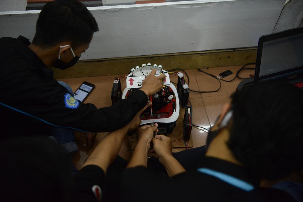 Anggota tim  Keluarga Mahasiswa Teknik Elektro (KMTE) Robot Research Universitas Muhammadiyah Surakarta menyiapkan robot penyemprot ruangan yang akan diikutsertakan dalam Kontes Robot Indonesia di gedung auditorium UMS, Kartasura, Sukoharjo, Jawa Tengah, Jumat (25/9/2020). KRI kembali digelar oleh Pusat Prestasi Nasional dengan mempertandingkan divisi Kontes Robot Pemadam Api Indonesia, Kontes Robot Sepak Bola Indonesia Beroda, Kontes Robot Sepak Bola Indonesia Humanoid, Kontes Robot Seni Tari Indonesia , dan Kontes Robot Tematik Indonesia. 