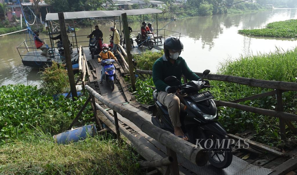 Warga turun dari perahu tambang di kawasan Wonorejo Timur, Surabaya, Jawa Timur, Jumat (17/3/2023).