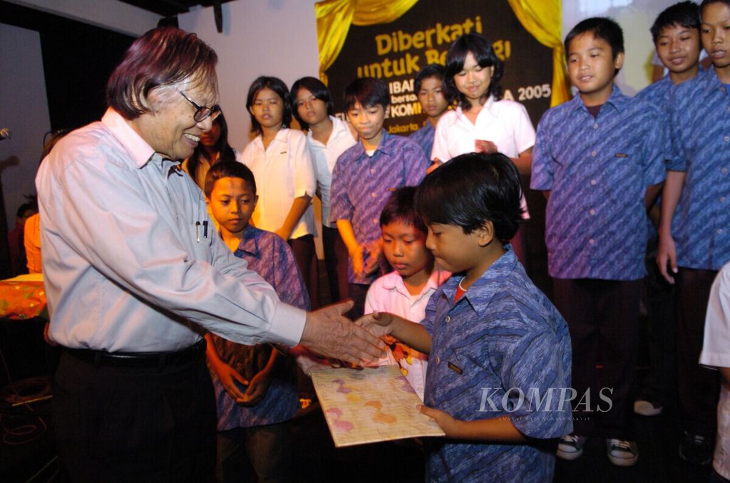 Pemimpin Kelompok Kompas Gramedia (KKG) Jakob Oetama, Jumat (6/1), menyerahkan bantuan kepada anak-anak yatim piatu pada acara perayaan Natal bersama di Bentara Budaya Jakarta.