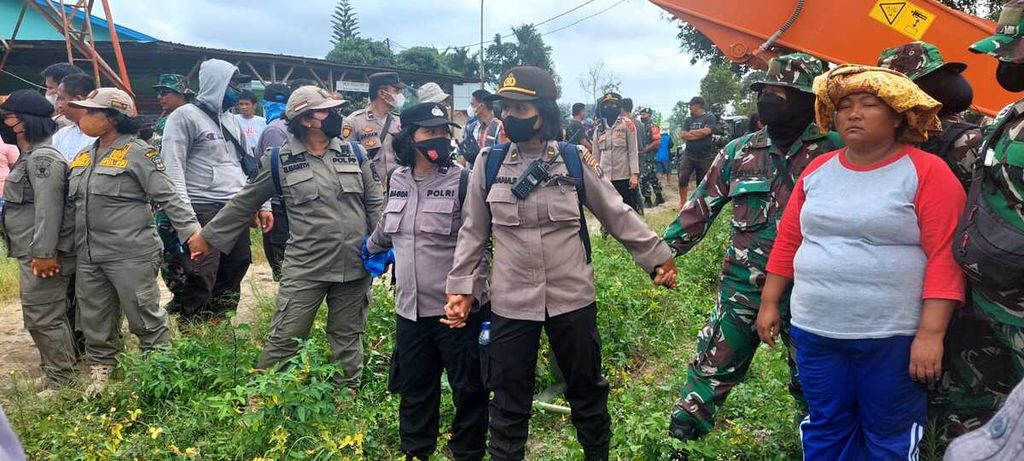 Warga menghadang petugas yang menjaga alat berat yang merobohkan rumah warga di lahan konflik masyarakat dengan PT Perkebunan Nusantara III di Kelurahan Gurilla, Kecamatan Siantar Sitalasari, Kota Pematang Siantar, Sumatera Utara, Jumat (25/11/2022).