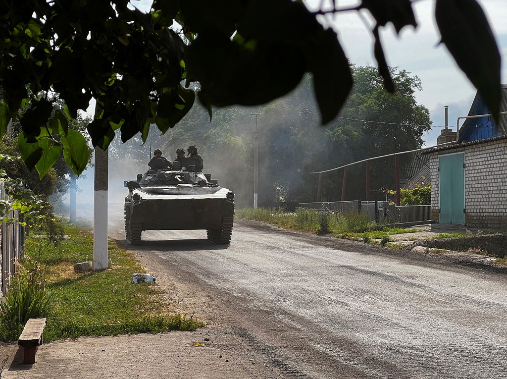 Militer Ukraina, Minggu (26/6/2022), mengendarai kendaraan militer berat saat masih berupaya untuk mengamankan kota  dari serbuan militer Rusia. Kini, kota itu telah sepenuhnya jatuh ke tangan militer Rusia dan memaksa militer Ukrainia mundur. 