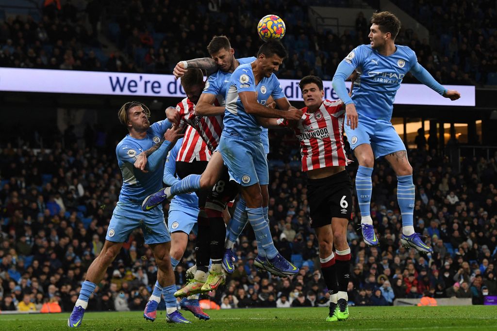 Para pemain Manchester City dan Brentford berebut bola dalam pertandingan sepak bola Liga Inggris antara Manchester City dan Brentford di Stadion Etihad di Manchester, barat laut Inggris, Rabu (9/2/2022). 2 gol kemenangan Manchester City dicetak oleh Riyad Mahrez melalui tendangan penalti pada menit ke-40 dan Kevin De Bruyne di menit ke-69.