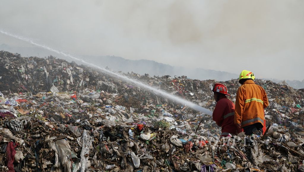 Petugas berupaya memadamkan kobaran api yang muncul pada tumpukan sampah yang menggunung, di TPA Putri Cempo, Kota Surakarta, Jawa Tengah, Sabtu (16/9/2023). Diduga, cuaca panas menjadi penyebab terjadinya kebakaran tersebut.