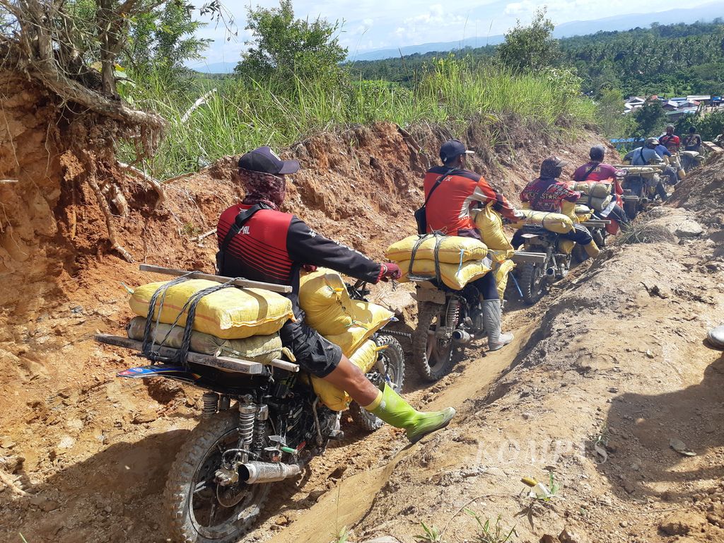 Proses pengangkutan material tambang emas liar di Gunung Botak, Pulau Buru, Maluku,  Selasa (20/6/2023). Terbit angkutan Rp 50.000 per karung. MIND.ID selaku <i>holding </i>pertambangan di bawah Kementerian Badan Usaha Milik Negara sedang mencari solusi pengelolaan tambang itu.