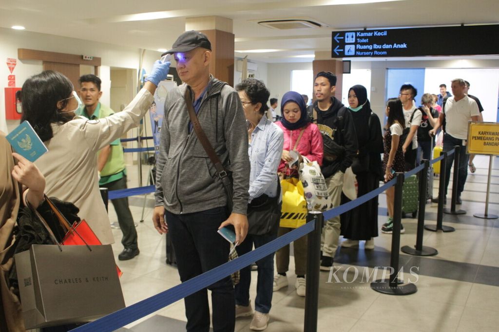 Petugas petugas bagian epidemiologi Kantor Kesehatan Pelabuhan (KKP) Bandung (kiri) sedang memindai suhu tubuh penumpang dari penerbangan Singapura dengan menggunakan termometer infra merah non kontak di Bandar Udara Internasional Husein Sastranegara, Kota Bandung, Jawa Barat, Kamis (16/5/2019).