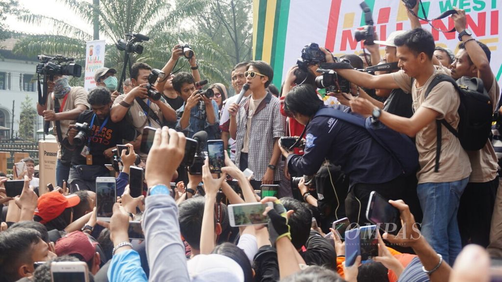 Pemeran utama film <i>Dilan: 1990 </i>dan <i>Dilan: 1991</i>, Iqbal Ramadhan, menyapa penggemar di depan Gedung Sate, Bandung, Jawa Barat, Minggu (24/2/2019).