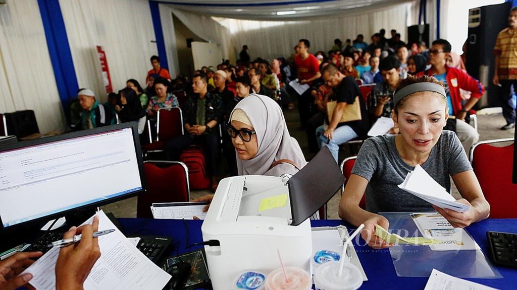 Wajib pajak mendengarkan petugas tentang tata cara pelaporan surat pemberitahuan (SPT) PPh orang pribadi melalui aplikasi e-filling di Kantor Pelayanan Pajak Pratama Jakarta, Kebayoran Lama, Jakarta Selatan, Kamis (29/3/2018).