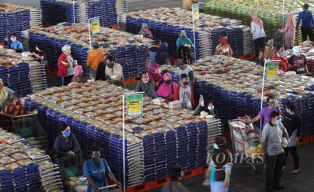 Warga mengantri membayar sejumlah kebutuhan yang mereka beli di Lumbung Pangan Jatim di JX International, Surabaya, Jawa Timur, Selasa (21/4/2020).