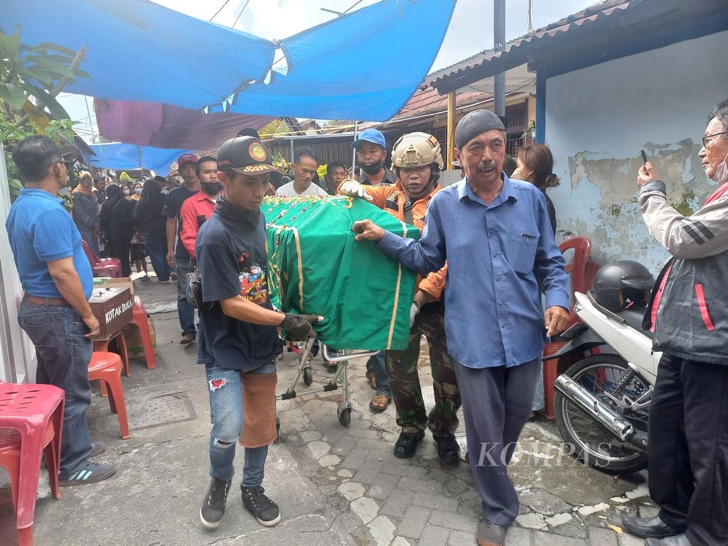 Warga mendorong peti berisi jenazah Ayu Indraswari (34) dari rumah duka di Kampung Suryoputran, Kelurahan Panembahan, Kecamatan Kraton, Kota Yogyakarta, Daerah Istimewa Yogyakarta (DIY), Senin (20/3/2023) sore. 