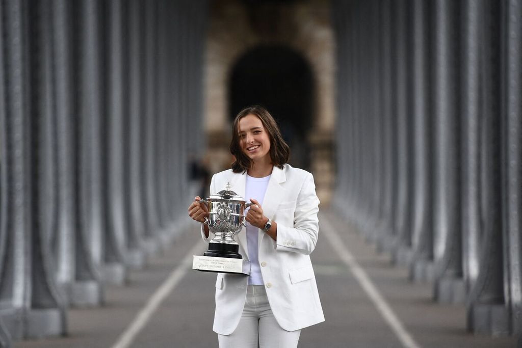 Petenis putri Polandia, Iga Swiatek, berfoto dengan torfi Susan Lenglen, lambang juara tunggal putri Grand Slam Perancis Terbuka di Pont de Bir-Hakeim, Paris, 5 Juni 2022. Setelah hasil kurang memuaskan di lapangan rumput, Swiatek kembali tampil di lapangan keras menuju Grand Slam AS Terbuka, dimulai dengan mengikuti WTA 1000 Toronto, 8-14 Agustus. 