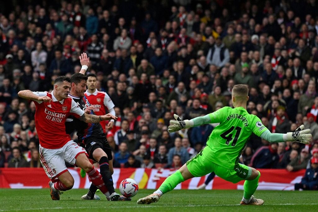 Pemain Arsenal Granit Xhaka (kiri) mengecoh kiper Crystal Palace Joseph Whitworth (kanan) untuk mencetak gol pada laga Liga Ingris di Stadion Emirates, London, Minggu (19/3/2023) WIB. Pada laga itu, Arsenal menang dengan skor 4-1.