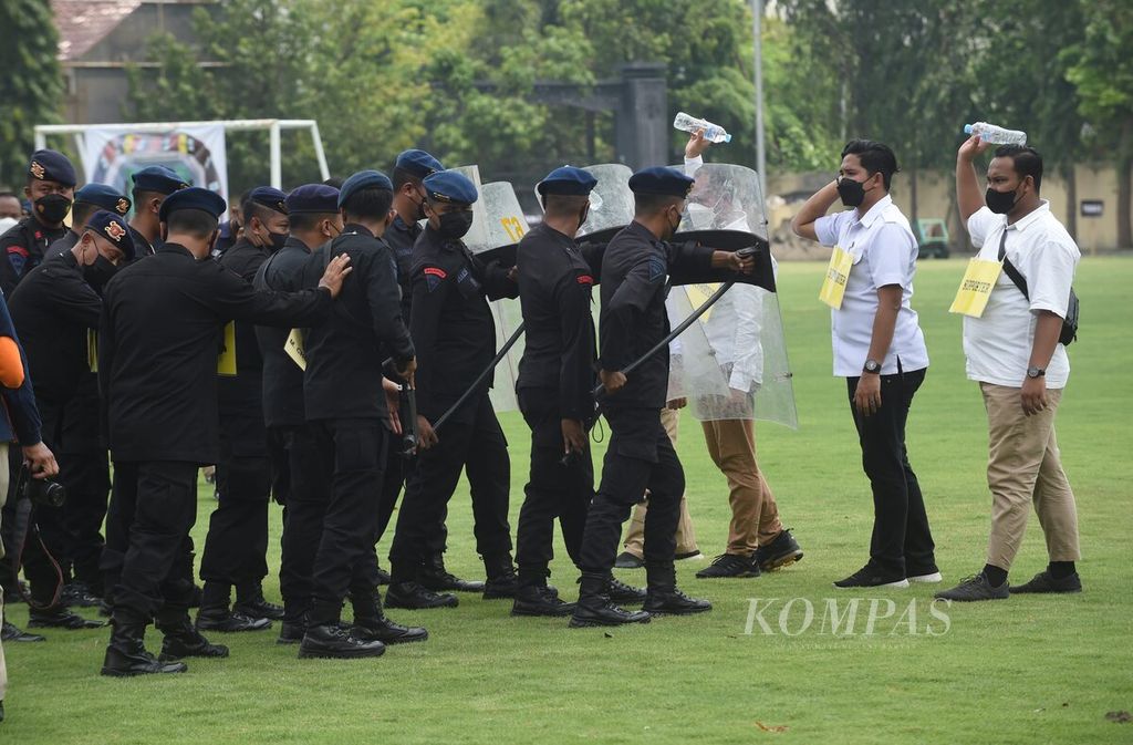 Reka ulang anggota kepolisian berhadapan dengan suportes saat Tim Bareskrim Mabes Polri dan Polda Jawa Timur merekonstruksi ulang tragedi Stadion Kanjuruhan, Malang, di Lapangan Sepakbola Markas Polda Jawa Timur, Surabaya, Jawa Timur, Rabu (19/10/2022).