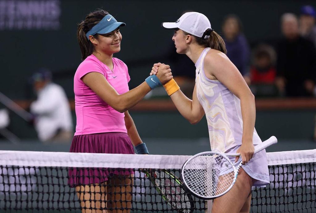 Petenis Inggris Emma Raducanu memberikan selamat kepada petenis Polandia Iga Swiatek setelah pertandingan babak keempat turnamen WTA 1000 Indian Wells di Stadion 1 Indian Wells Tennis Garden, California, Amerika Serikat, Selasa (14/3/2023) malam waktu setempat atau Rabu WIB. Swiatek menang dengan skor 6-3, 6-1. 