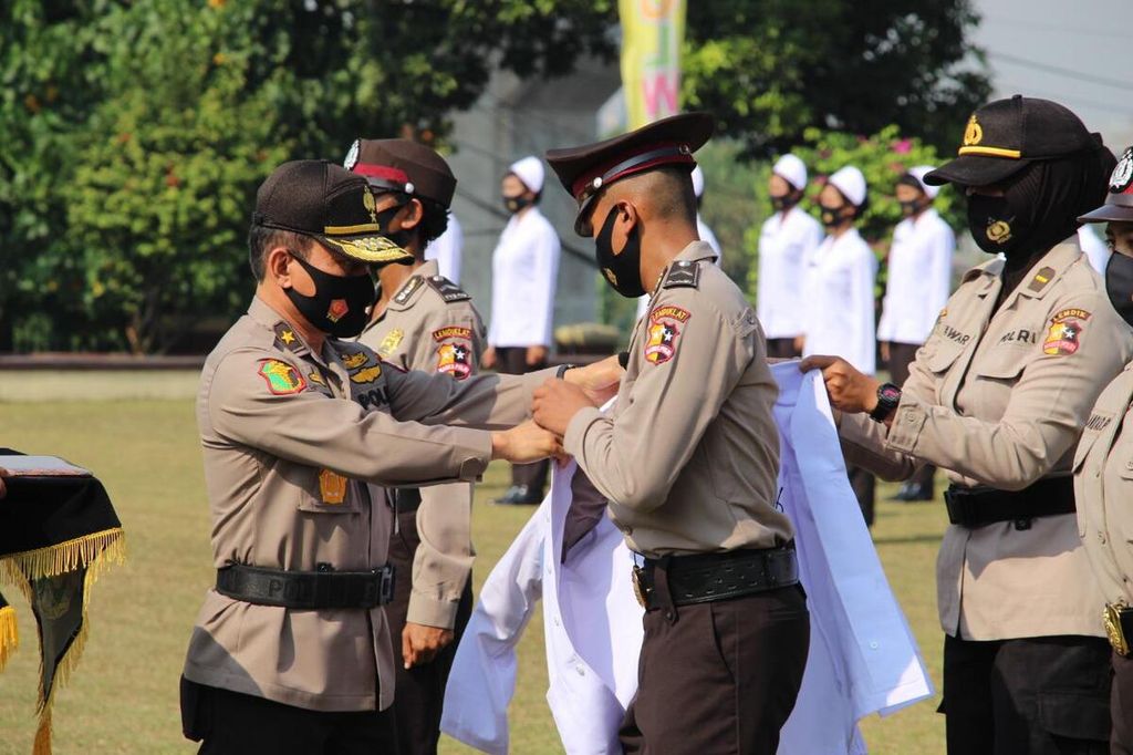 Kepala Pusat Kedokteran dan Kesehatan (Kapusdokkes) Polri Brigadir Jenderal (Pol) Rusdiyanto memakaikan baju perawat kepada para bintara berkompetensi khusus perawat dan bidan yang baru dilantik dalam acara pelantikan, Senin (31/8/2020), sebagai simbol penyerahan dari Lemdiklat Polri kepada Pusdokkes Polri.