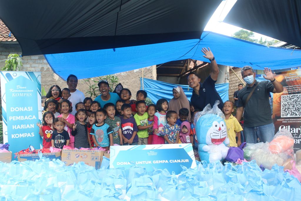 Anak- anak berfoto bersama sejumlah perwakilan dari Kompas Gramedia dan , musisi di Kampung Sedong Kulon, Kelurahan Bojongherang, Kecamatan Cianjur, Kabupaten Cianjur, Jawa Barat, Sabtu (21/1/2023). 