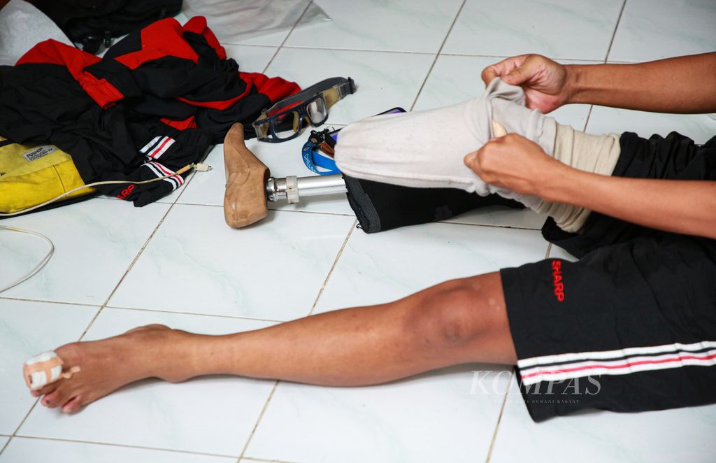 Pemain timnas sepak bola amputasi yang tergabung dalam Perkumpulan Sepak Bola Amputasi Indonesia (PSAI), Imat Hermawan alias Ujay, mengenakan kaki palsunya saat akan beraktivitas di mes tempat mereka menjalani <i>training center</i> di kawasan Pasar Minggu, Jakarta Selatan, Kamis (31/3/2022).