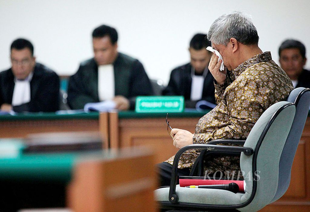 Mantan Ketua Mahkamah Konstitusi yang menjadi terdakwa dalam kasus dugaan suap penanganan sengketa pilkada di MK, Akil Mochtar, mengusap wajahnya saat mengikuti sidang di Pengadilan Tindak Pidana Korupsi, Jakarta, Kamis (27/2/2014). Dalam kesempatan itu, ia meminta Majelis Hakim menolak dakwaan dan membebaskan dirinya. 