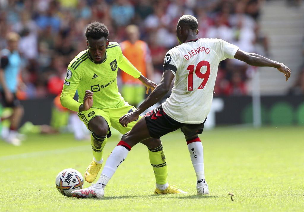 Pemain Manchester United, Anthony Elanga (kiri), dan pemain Southampton, Moussa Djenepo, berebut bola dalam pertandingan Liga Inggris antara Southampton dan MU di Stadion St Mary, Southampton, Sabtu (27/8/2022). MU mengalahkan tuan rumah, 1-0, melalui gol yang dicetak Bruno Fernandes.