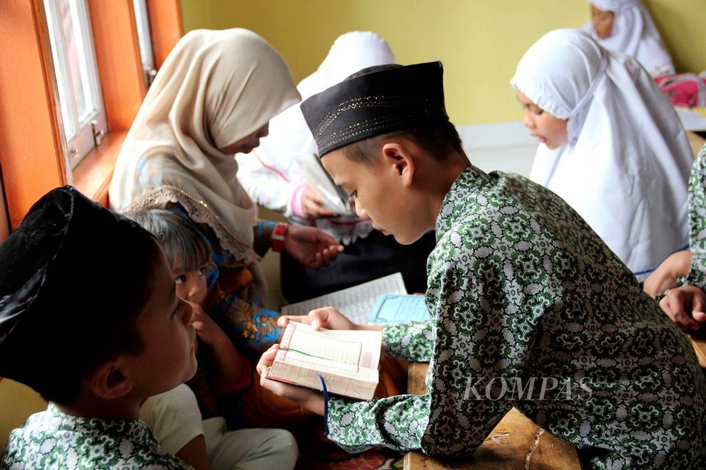 Murid-murid surau Gadang Haji Miskin di Nagari Pandai Sikek di Kecamatan Sepuluh Koto, Kabupaten Tanah Datar, Sumatera Barat sedang mengaji Al Quran dibimbing gurunya (24/1/2018). Surau di Minangkabau memiliki sejarah panjang dan telah melahirkan banyak tokoh bangsa. Surau Minangkabau masa kini lebih banyak mengikuti kurikulum formal pemerintah, sementara pada masa lalu surau merupakan pusat aktivitas dan pendidikan nonformal pemuda Minangkabau.